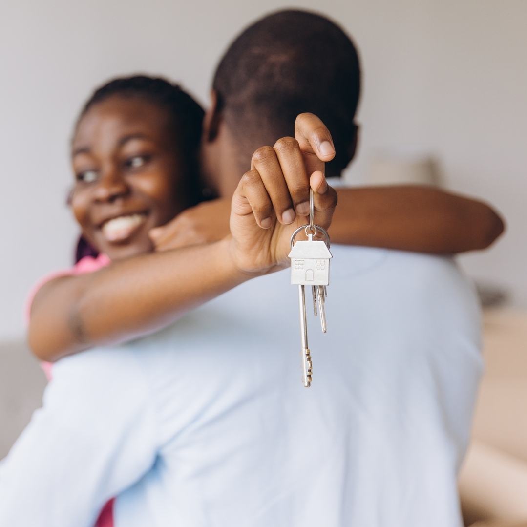 Young couple holding the keys to their new home